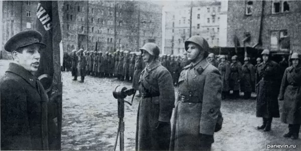 Член Военного Совета фронта А. А. Кузнецов вручает гвардейское знамя 14-му артиллерийскому полку