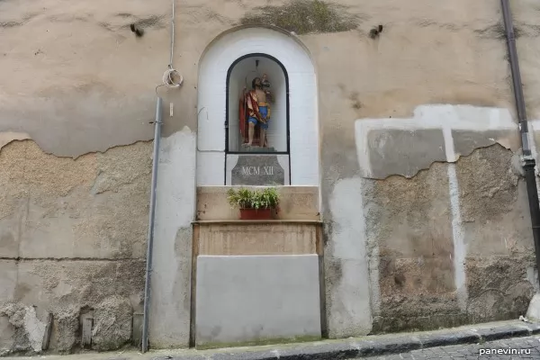 Фигура святого в стене дома