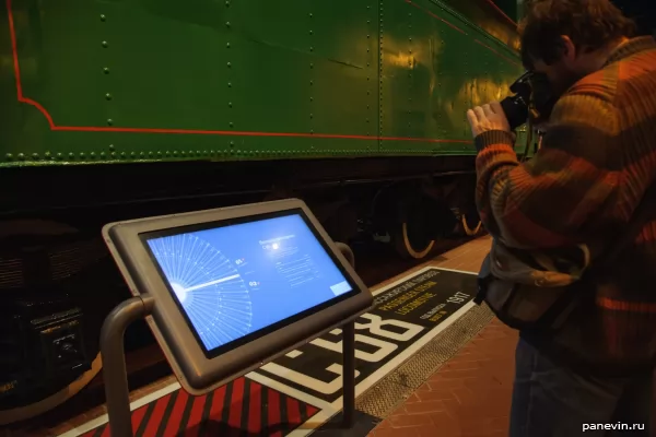 Visitor photographs the screen with the steam locomotive description