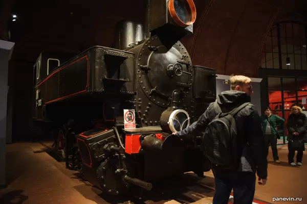 Посетитель музея фотографируется с паровозом