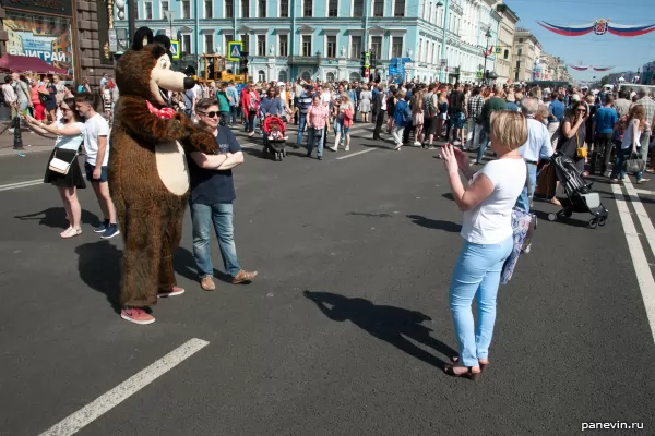 Passers-by are photographed with a cartoon bear