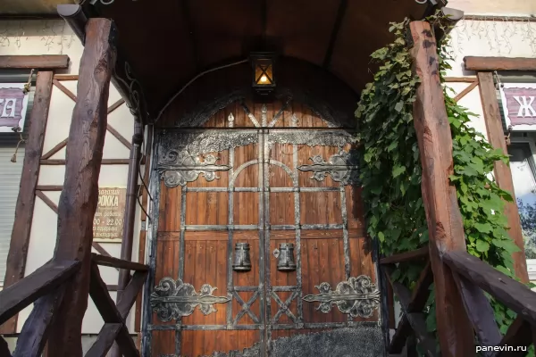 Wooden door with forged elements