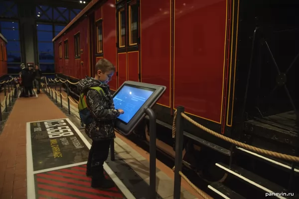 boy studies the description of the pre-revolutionary mail van