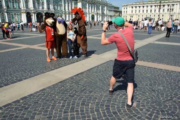 Football fans are photographed with a cartoon horse and bear